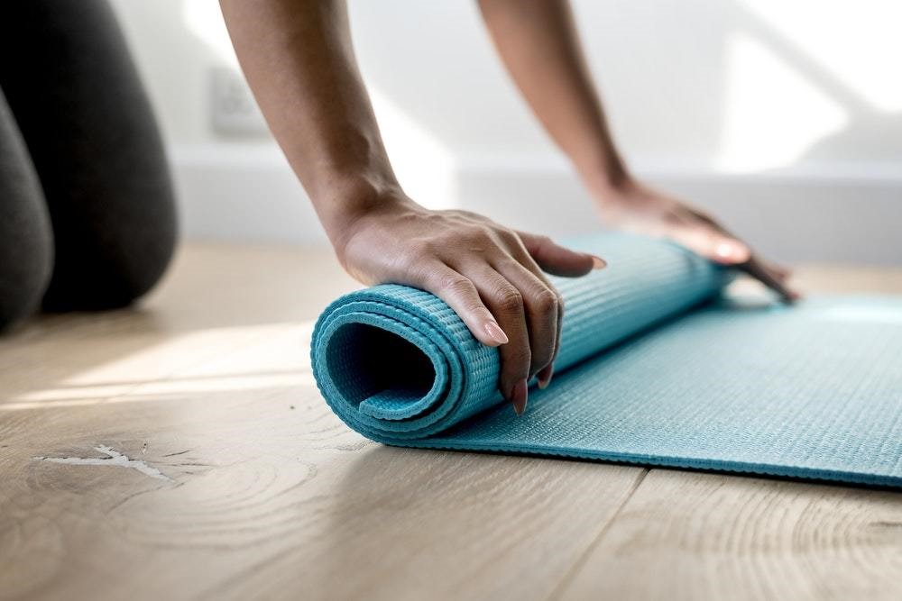 blue yoga mat being rolled up