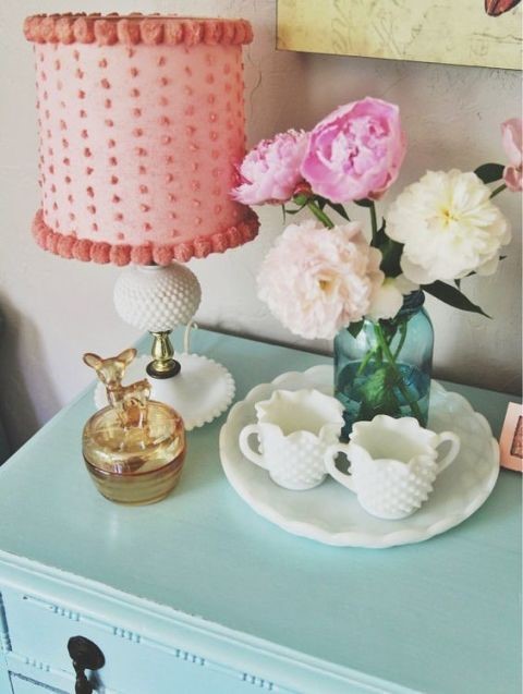 elegant teal night stand with pink fluffy lamp and blue vase with flowers