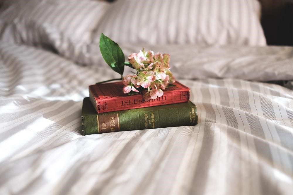 green book and red book with flowers on top