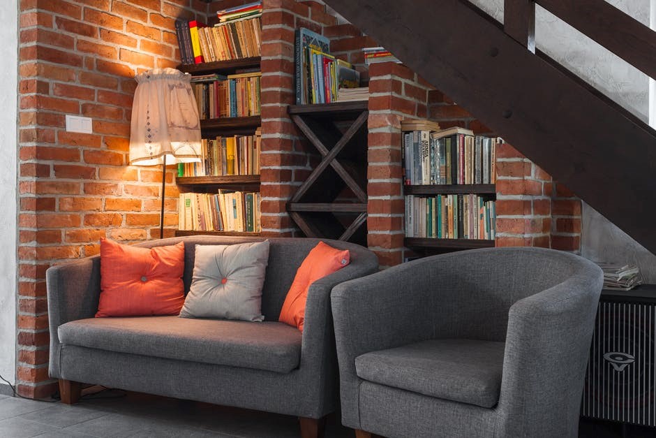 grey couches in a comfy reading nook under the stairs