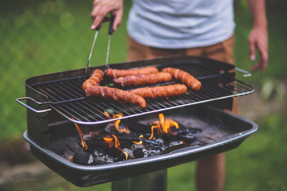 A man grilling hot dogs on a grill