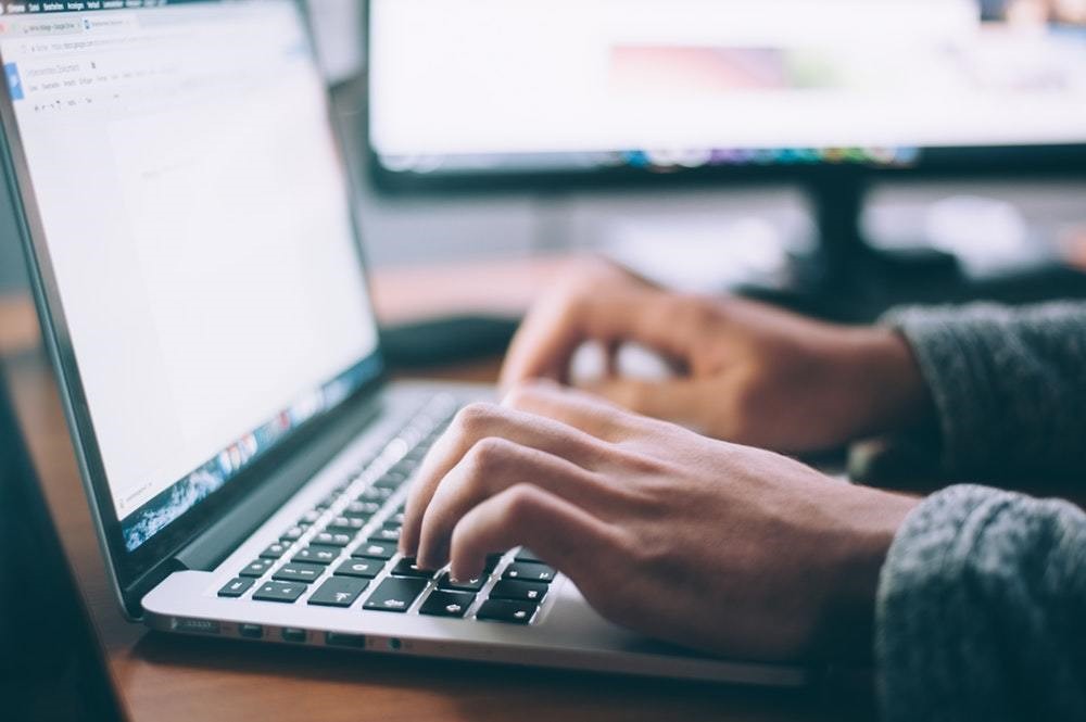 picture of hands typing on macbook