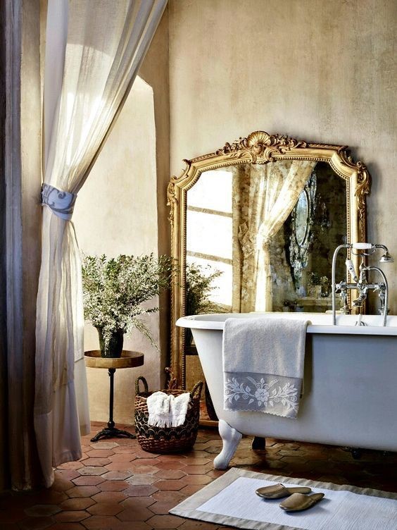 mirror on the wall in bathroom with claw tub bath