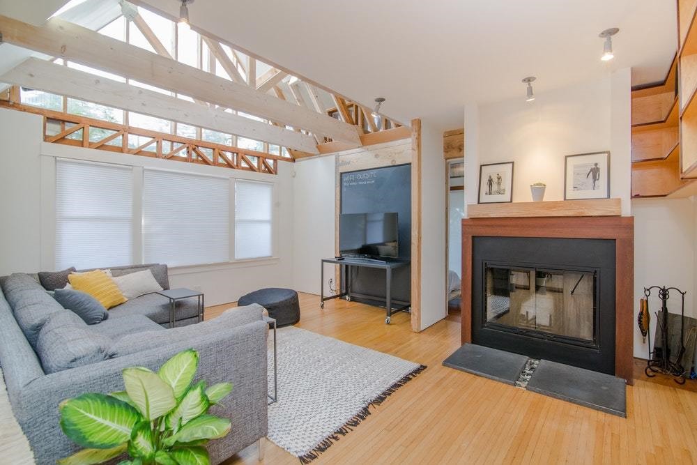 modern living room with light colored wood floors and fireplace