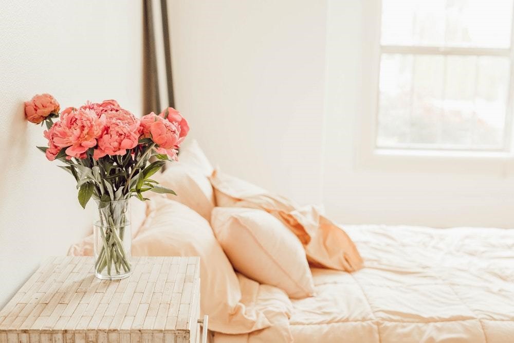 pink flowers next to beige bedspread