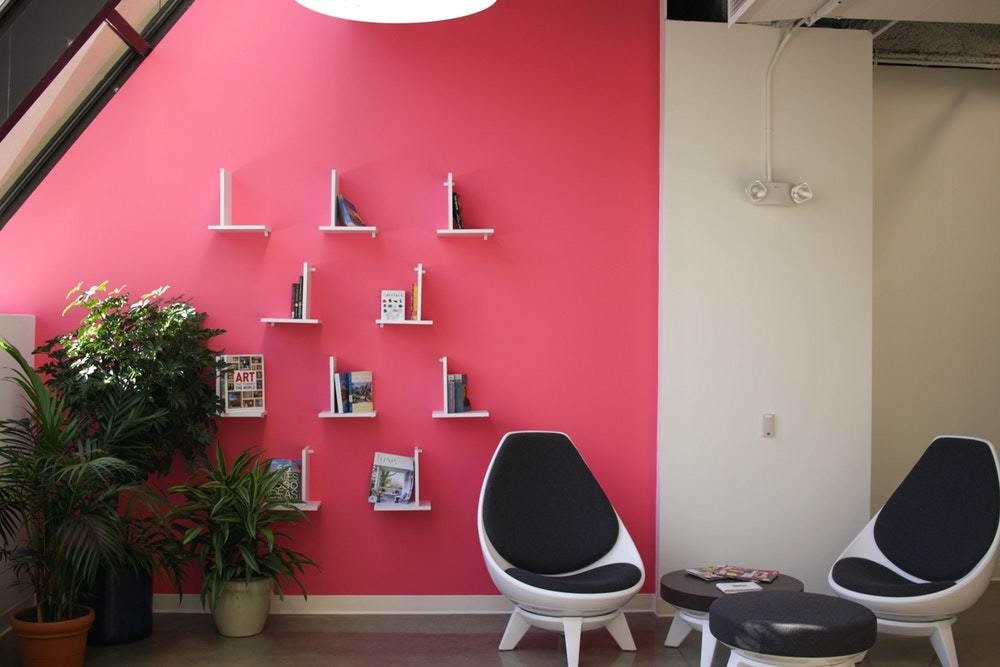  pink wall rom with blue and white modern chairs