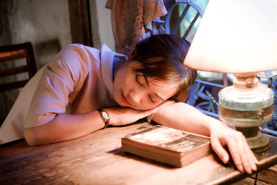 Girl Sleeping on table next to light