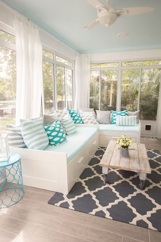 teal color pop pillows against white and light blue couch