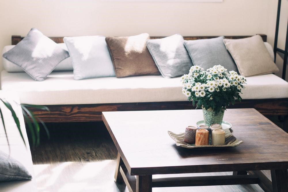 white wooden couch with mutual blue color pillows